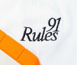 A close up of the 91 Rules workmark embroidered on a ribbed cotton.